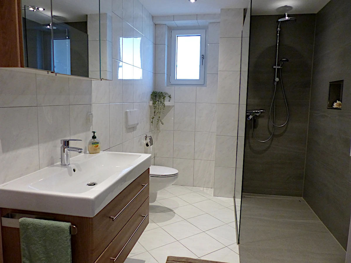 Bad mit bodenebener Dusche und Fenster