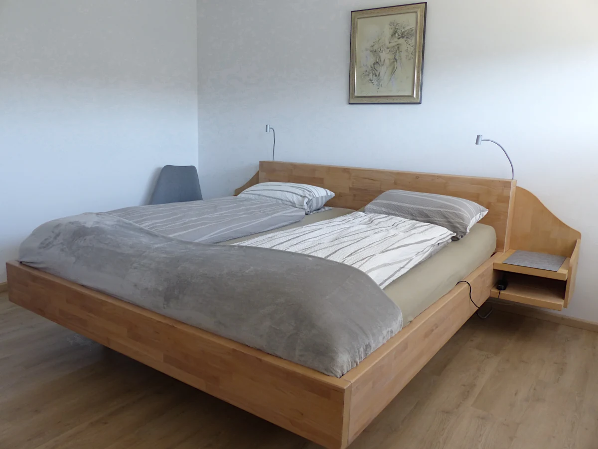 großes Schlafzimmer mit Doppelbett und Nachtkonsolen